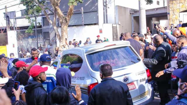 Carro funerário com caixão do cantor Mc Kevin é cercado por fãs