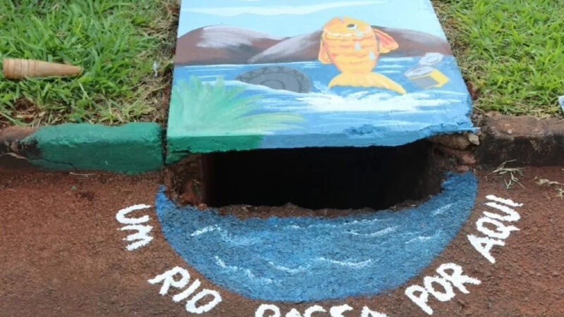 Crianças pintam bueiros para alertar adultos sobre descarte de lixo