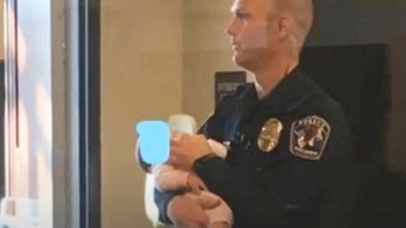 Policial segura bebê, ajuda mãe a denunciar abuso e foto e viraliza