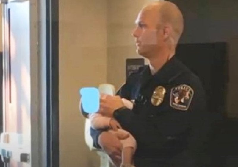 Policial segura bebê, ajuda mãe a denunciar abuso e foto e viraliza
