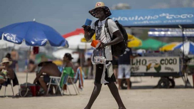 Sol e calor projetam estrada cheia e praia lotada no feriado
