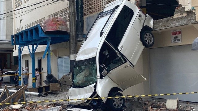 Carro atravessa parede de garagem, cai de prédio e mulher fica ferida