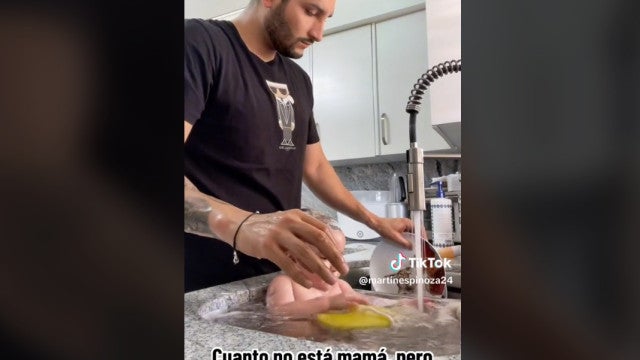 Pai gera polêmica ao lavar pratos e dar banho no filho no mesmo local