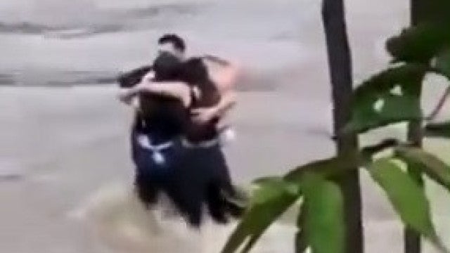 Amigos se abraçam antes de serem arrastados por enchente