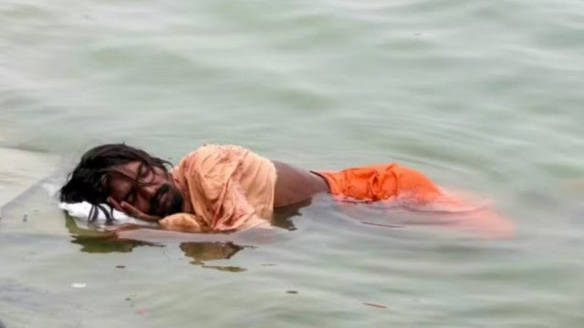Homem dribla calor do verão indiano com soneca no Rio Ganges