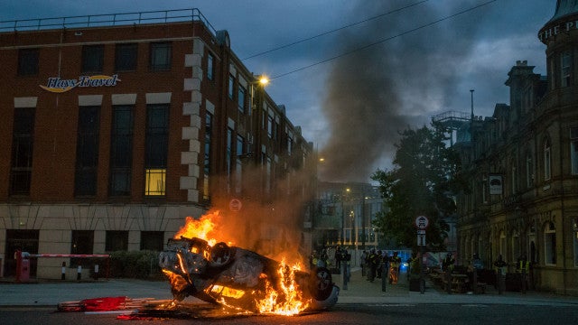 Menino é detido por incendiar carro da policia em protesto na Inglaterra